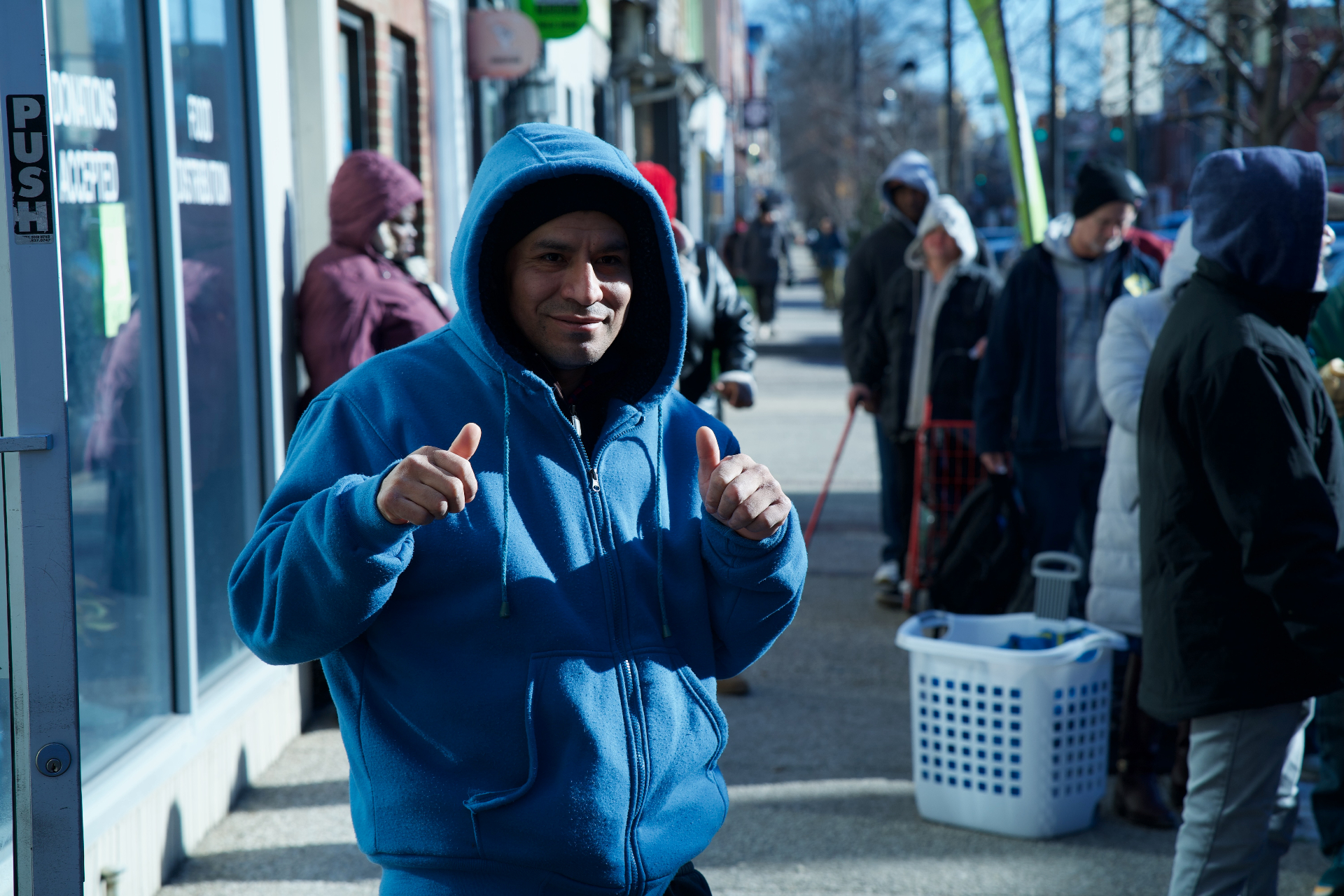 Person giving thumbs up at food distribution event